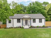 Charming home featuring a white brick facade, well-manicured lawn, and classic architectural details at 2114 Thurmond Pl, Charlotte, NC 28205