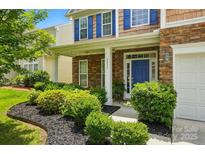 Charming two-story home with a stone facade, blue shutters, and a beautifully landscaped front yard at 2233 Sonoma Valley Dr, Charlotte, NC 28214