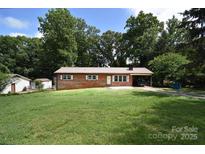 Charming brick home with a metal roof, spacious front yard, and a convenient carport at 2625 Glenn St, Newton, NC 28658