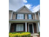 Charming two-story townhouse with brick accents, dark shutters and a well-manicured front yard at 3208 Barons Court Rd, Charlotte, NC 28213