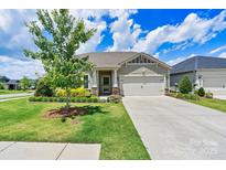 Charming single-story home boasts a well-manicured lawn, mature tree, and an inviting two-car garage at 4197 Canopy Creek Dr, Denver, NC 28037