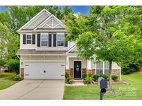 Charming two-story home features a two-car garage, stone accents, and a welcoming front porch at 424 Castlebury Ct, Clover, SC 29710