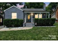 Charming home featuring a covered front porch, lush landscaping, and gray painted brick at 432 4Th Street Sw Pl, Hickory, NC 28602