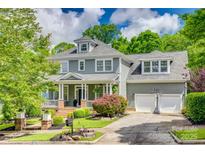 Charming two-story home featuring a covered porch, manicured landscaping, and a two-car garage at 5518 Morris Hunt Dr, Fort Mill, SC 29708
