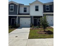 Modern two-story townhome with a one-car garage, manicured lawn, and neutral-colored exterior at 6114 Starview Ter, Charlotte, NC 28216
