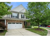Charming two-story home featuring stone accents, a two-car garage, and a well-maintained front yard with mature trees at 7130 Maricopa Rd, Charlotte, NC 28277