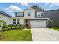Charming two-story home features a red door, manicured lawn, and a two-car garage on a sunny day at 9930 Cask Way, Huntersville, NC 28078