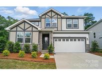 Charming two-story home with stone accents, a well-manicured yard and a two car garage at 9957 Cask Way, Huntersville, NC 28078