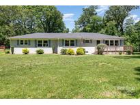 Charming single-story home with blue shutters and a well-manicured lawn at 1632 Charles Raper Jonas Hwy, Mount Holly, NC 28120