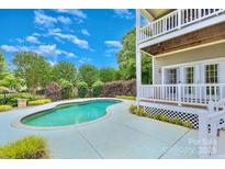 Inviting backyard pool area with meticulously maintained landscaping and a two-story deck at 187 Spring Run Dr, Mooresville, NC 28117