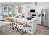Bright kitchen with white cabinets, stainless steel appliances, and a large island with bar seating at 2485 Hedgecliff Rd, Kannapolis, NC 28025