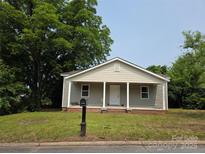 Charming single-story home with gray siding, a welcoming front porch, and a well-maintained lawn at 38 Holly St, Great Falls, SC 29055