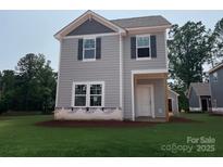 New construction two-story home features gray siding, black shutters, and a covered front porch, blending modern design with classic charm at 4040 Grommet Ct, Matthews, NC 28105