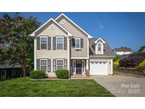 Charming two-story home featuring a well-manicured lawn, attached garage, and classic architectural details at 418 Eastway Sw Ln, Conover, NC 28613