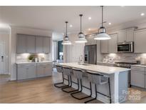 Modern kitchen features a large island with seating and stainless steel appliances at 5948 Chumbley Point Rd # 79, Charlotte, NC 28215