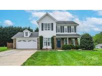 Charming two-story home featuring a lush green lawn, attached garage, and classic architectural details at 600 Capella Ct, Gastonia, NC 28056
