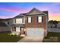Charming two-story brick home with a manicured lawn and attached two-car garage, perfect for suburban living at 7172 Teague Dr, Gastonia, NC 28056