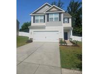Charming two-story home with a white garage door, black shutters, and a well-manicured lawn on a sunny day at 7209 Cuddington Dr, Charlotte, NC 28215