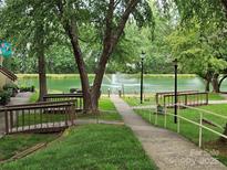 A serene view of the community pond and fountain, enhanced by mature trees and lush landscaping at 7329 Winery Ln, Charlotte, NC 28227