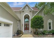 Stunning front entrance featuring a large, arched doorway and beautifully landscaped walkway at 7600 Dunsmuir Ct, Cornelius, NC 28031