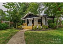 Charming home featuring a welcoming front porch and beautifully landscaped front yard with mature trees at 940 N New Hope Rd, Gastonia, NC 28054