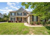 Charming two-story home with a stone and siding exterior, black shutters, and a well-manicured lawn at 9814 Tompkins Ln, Waxhaw, NC 28173