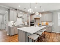 A spacious kitchen featuring an island with seating, stainless steel appliances, and pendant lighting at 9842 Quercus Ln, Huntersville, NC 28078