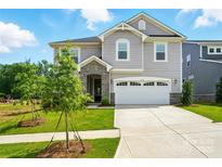 Charming two-story home boasts a two-car garage, stone accents, manicured lawn, and inviting curb appeal at 9934 Cask Way, Huntersville, NC 28078