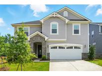 Charming two-story home boasts a two-car garage, stone accents, manicured lawn, and inviting curb appeal at 9934 Cask Way, Huntersville, NC 28078
