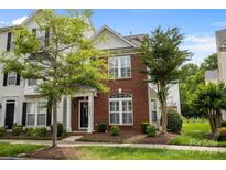 Charming two-story brick townhome featuring a well-manicured lawn and lush landscaping at 10455 Alexander Martin Ave, Charlotte, NC 28277