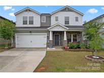 Charming two-story home with a two-car garage and stone veneer accents at 12536 Stoneybrook Pkwy, Huntersville, NC 28078