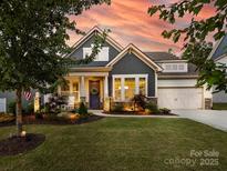 Charming home featuring a landscaped front yard, inviting porch, and stylish architectural details at 14128 Morningate St, Huntersville, NC 28078
