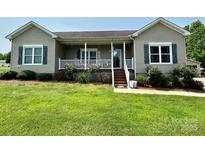 Charming one-story home features a welcoming front porch and neatly landscaped front yard at 1545 Lewis Farm Rd, Kings Mountain, NC 28086