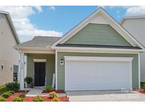 Charming one-story home featuring light green siding, a white garage door, and a well-maintained front yard at 1770 Troon Dr, Salisbury, NC 28144