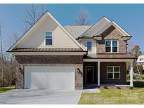 Charming two-story home with a brick and siding exterior, attached two car garage and well manicured front yard at 231 Brook Se Ave, Concord, NC 28025