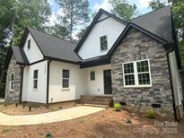 Beautiful home exterior with stone accents, white vertical siding, and a welcoming front entrance at 248 Pioneer Dr, Mount Gilead, NC 27306