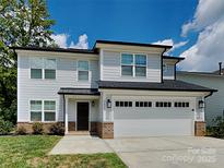 New construction home featuring neutral siding, black trim, and a two-car garage at 2620 Poplar Cove Nw Dr, Concord, NC 28027