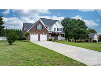 Charming two-story brick home with a spacious front yard and two-car garage offers curb appeal at 2779 Touchstone Cir, Newton, NC 28658