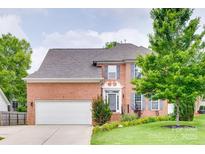 Charming two-story red brick home with a well-manicured lawn and lush landscaping at 3725 Leela Palace Way, Fort Mill, SC 29708