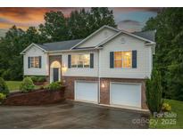 Charming two-story home featuring a brick facade, vinyl siding, and an attached two-car garage at 4059 Caitlins Way, Hickory, NC 28602