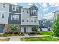 Charming townhouse with a mix of brick and siding and manicured front yard with beautiful landscaping at 4439 Millennium Ave, Charlotte, NC 28217