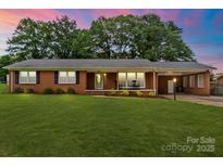 Charming brick home featuring a large front yard and covered parking at 505 Melody Ln, Shelby, NC 28152