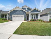 Charming home with blue siding, a well-manicured lawn, and a two-car garage at 6015 Waldorf Ave, Monroe, NC 28110