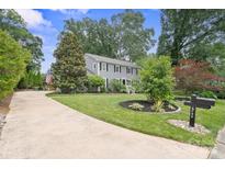 Charming two-story home with a well-manicured lawn and a long driveway leading to the house at 6745 Wheeler Dr, Charlotte, NC 28211