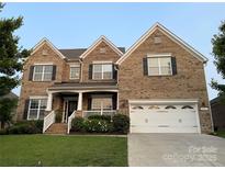 Charming two-story brick home featuring a manicured lawn and an attached two-car garage at 707 Five Leaf Ln, Waxhaw, NC 28173