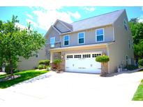 Charming two-story home with a two-car garage, lush landscaping, and a well-manicured lawn at 7170 Kenyon Dr, Denver, NC 28037