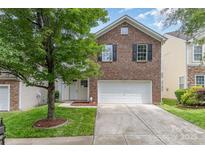 Charming brick home featuring an attached garage, manicured lawn, and mature shade tree in the front yard at 9630 Turning Wheel Dr, Charlotte, NC 28214
