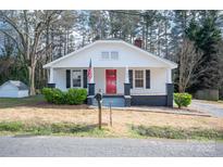 Charming one-story home with a bright red door, classic shutters, and an American flag at 113 Elwood St, Kannapolis, NC 28081
