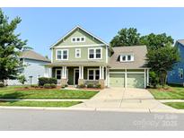 Charming two-story home with a welcoming front porch and well-maintained green lawn at 11324 Fullerton Place Nw Dr, Huntersville, NC 28078
