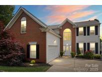 Charming two-story brick home with manicured landscaping and an attached two-car garage at 13528 Philip Michael Rd, Huntersville, NC 28078